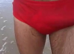 Trocando a cueca pela sunga na praia... de pau duro!